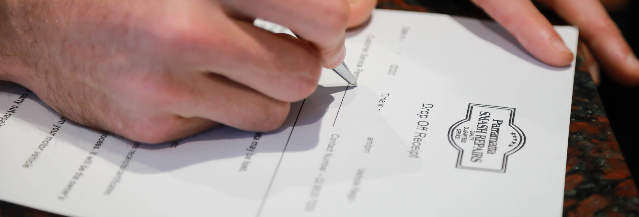 parramatta smash repair customer filling drop off receipt book an inspection banner